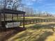 Cozy backyard swing beneath a pergola with a view of fenced-in pastureland at 77 Russell Rd, Lawrenceville, GA 30043