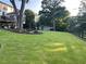 Expansive backyard with lush lawn, trees, and views of the home's deck and additional structures at 77 Russell Rd, Lawrenceville, GA 30043