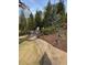 Stone walkway leading to a backyard fire pit area with chairs, surrounded by landscaping at 77 Russell Rd, Lawrenceville, GA 30043