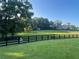 Expansive green backyard bordered by a black fence, perfect for recreation or livestock at 77 Russell Rd, Lawrenceville, GA 30043