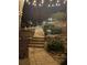 Stone steps and professional outdoor lighting create a serene and inviting backyard atmosphere at night at 77 Russell Rd, Lawrenceville, GA 30043