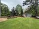 Large backyard with a storage shed, green grass, and stone retaining walls at 77 Russell Rd, Lawrenceville, GA 30043