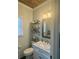 Half bathroom with a marble vanity, a modern mirror, and shelving for storage at 77 Russell Rd, Lawrenceville, GA 30043