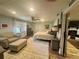 Bright bedroom featuring a ceiling fan, chair, ottoman, and doorway view of the fireplace at 77 Russell Rd, Lawrenceville, GA 30043