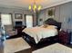 Primary bedroom featuring a chandelier, wall paneling, a bed, and two bedside tables with lamps at 77 Russell Rd, Lawrenceville, GA 30043