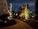 A long driveway and professional landscaping with beautiful lighting leading to the house at night at 77 Russell Rd, Lawrenceville, GA 30043