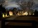 Beautiful exterior view of the home at night, showcasing professional landscaping with lights at 77 Russell Rd, Lawrenceville, GA 30043