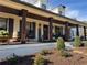 Inviting front porch with dark wood pillars, rocking chairs, and manicured landscaping at 77 Russell Rd, Lawrenceville, GA 30043