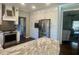 Well-lit kitchen showcasing a stainless steel refrigerator and oven against the marble island and white cabinets at 77 Russell Rd, Lawrenceville, GA 30043
