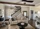 Cozy living room features a ceiling fan, exposed beam, a beige sofa, and beautiful dark hardwood floors at 77 Russell Rd, Lawrenceville, GA 30043