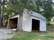 Side view of a storage shed in the backyard featuring wood siding and a metal roof at 77 Russell Rd, Lawrenceville, GA 30043