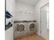 Convenient laundry room featuring modern appliances, a storage shelf, and a nearby doorway at 18 Torry Pines Cir, Villa Rica, GA 30180