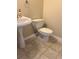 Pedestal sink and toilet in bathroom with neutral walls and tile floors at 4457 Webb Meadows Dr, Loganville, GA 30052