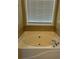 Bathroom featuring a large soaking tub with tile surround and natural light at 4457 Webb Meadows Dr, Loganville, GA 30052