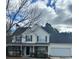 Charming two-story home with stone accents, a covered porch, and an attached garage at 4457 Webb Meadows Dr, Loganville, GA 30052