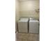 Laundry area includes a washer, dryer, shelf, and neutral tile flooring at 4457 Webb Meadows Dr, Loganville, GA 30052