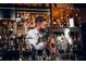 A bartender in an apron holds a cute dog at a well-stocked bar at 567 Ponce De Leon Ne Ave # 312, Atlanta, GA 30308