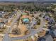 Aerial view shows community with pool and clubhouse surrounded by single-Gathering homes at 6645 Country Lake Rd, Cumming, GA 30041