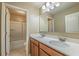 Bathroom featuring double sinks, wood cabinets, shower and tub combo with sliding glass doors at 6645 Country Lake Rd, Cumming, GA 30041