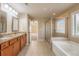 Bright bathroom featuring double vanity, soaking tub, and glass enclosed shower at 6645 Country Lake Rd, Cumming, GA 30041