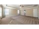 Large primary bedroom with a ceiling fan, tray ceiling, and three windows at 6645 Country Lake Rd, Cumming, GA 30041