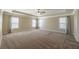 Large primary bedroom with tray ceiling, carpeted floors, and three windows at 6645 Country Lake Rd, Cumming, GA 30041