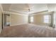 Large primary bedroom with tray ceiling, carpeted floors, and two windows at 6645 Country Lake Rd, Cumming, GA 30041