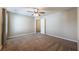 Large carpeted bedroom with a ceiling fan and a view to the hallway at 6645 Country Lake Rd, Cumming, GA 30041
