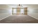 Large bonus room with neutral walls, carpeted flooring and two windows at 6645 Country Lake Rd, Cumming, GA 30041