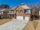 Attractive two-story home boasts a brick facade, spacious driveway, and a two-car garage at 6645 Country Lake Rd, Cumming, GA 30041
