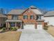 Inviting two-story brick home featuring a two-car garage and well-manicured front yard at 6645 Country Lake Rd, Cumming, GA 30041