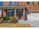 Welcoming front entrance with a decorative glass door, brick pillars, and lush landscaping, creating an inviting curb appeal at 6645 Country Lake Rd, Cumming, GA 30041