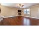 Spacious living room featuring hardwood floors, a stone fireplace, and large windows, creating a bright and airy atmosphere at 6645 Country Lake Rd, Cumming, GA 30041