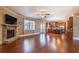 Open-concept living room with a stone fireplace, hardwood floors, and abundant natural light, perfect for relaxation and entertaining at 6645 Country Lake Rd, Cumming, GA 30041