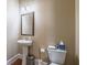 Cozy powder room featuring a pedestal sink, framed mirror, and modern fixtures, offering convenience and style at 6645 Country Lake Rd, Cumming, GA 30041