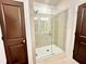 A shower with tile walls and doors, and dark brown trim at 542 Sawnee Village Blvd # D69, Cumming, GA 30040
