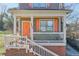 Charming home with a front porch, orange door and shutters, and green rocking chairs at 660 Delbridge Nw St, Atlanta, GA 30314