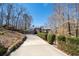 A charming home featuring a stone facade, attached garage, and long, curved driveway at 8700 The Fifth Grn, Atlanta, GA 30350