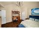 Well-lit bedroom featuring wood floors and a desk with a hutch and an office chair at 4215 Idlewood Dr, Cumming, GA 30040