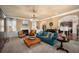 Inviting living room with blue sofa, stylish chandelier, and abundant natural light streaming through large windows at 4215 Idlewood Dr, Cumming, GA 30040