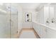 Bright bathroom showcasing a glass shower, marble tile, and a modern vanity with dual sinks at 47 Colonial Ter, Villa Rica, GA 30180