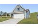 View of the home showing blue siding, a white garage door, and well-maintained green lawn at 47 Colonial Ter, Villa Rica, GA 30180