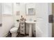 Cozy half bathroom with a white pedestal sink, decorative shelving, and wood-look flooring at 7652 Baron Rd, Fairburn, GA 30213