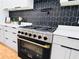 Modern kitchen featuring stainless steel appliances, gray cabinetry, and a sleek, black tile backsplash at 842 Laurelmont Sw Dr, Atlanta, GA 30311