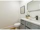 Modern powder room featuring gray vanity and a stylish black-framed mirror at 842 Laurelmont Sw Dr, Atlanta, GA 30311