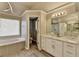 Bright bathroom with double vanity, modern lighting, soaking tub and separate shower behind an open door at 10683 Glenleigh Dr, Johns Creek, GA 30097