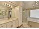 Bright bathroom with double vanity, modern lighting, and a shower that has glass door at 10683 Glenleigh Dr, Johns Creek, GA 30097