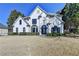 Two-story home featuring a well-maintained lawn, trimmed hedges, and a classic white facade at 10683 Glenleigh Dr, Johns Creek, GA 30097