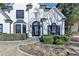 Close up of two-story home featuring a well-maintained lawn, trimmed hedges, and a classic white facade at 10683 Glenleigh Dr, Johns Creek, GA 30097