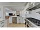 Bright kitchen with island, stainless steel appliances, and view to living room with fireplace at 10683 Glenleigh Dr, Johns Creek, GA 30097